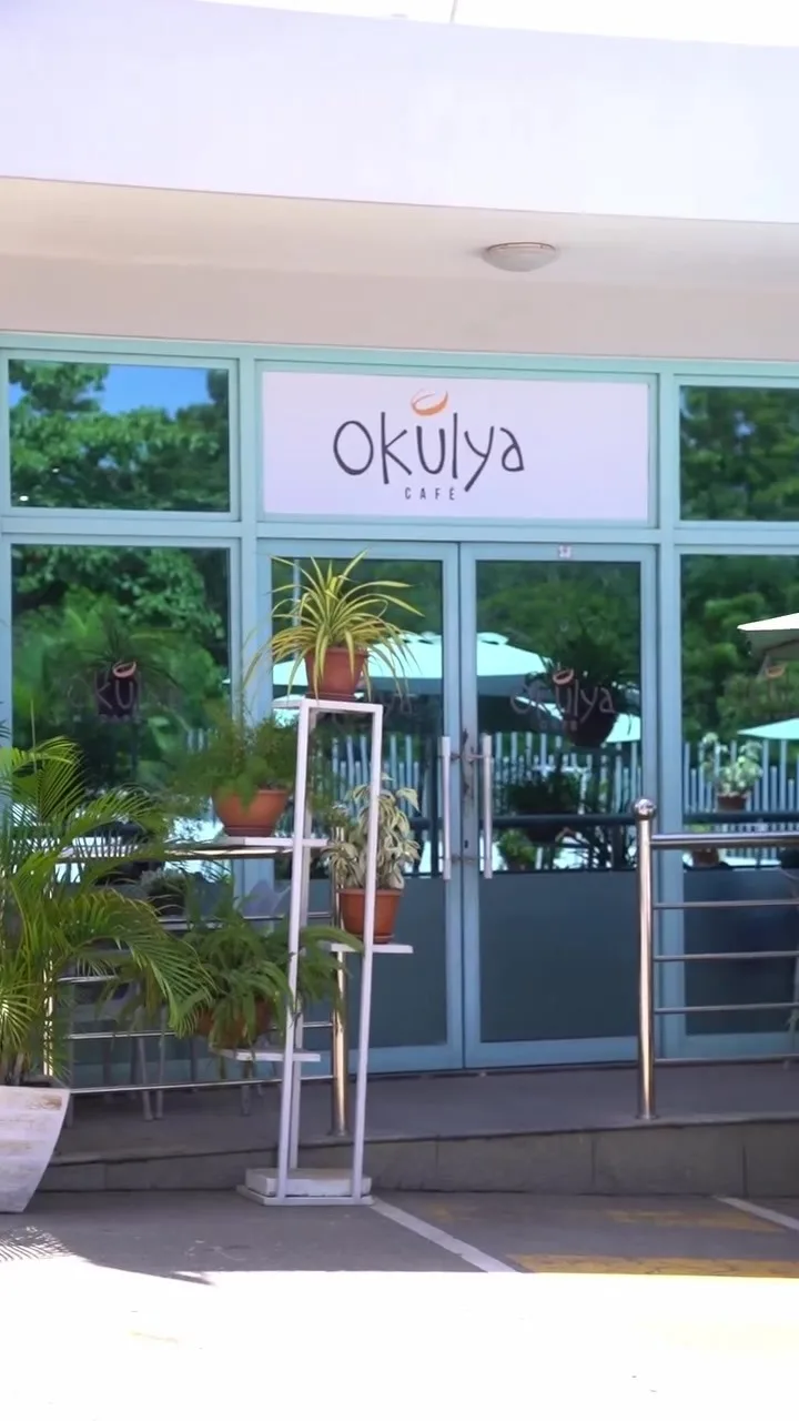 Entrada do Okulya Café, com as portas de vidro e o letreiro